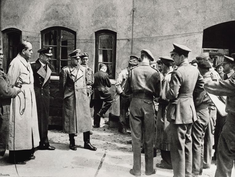 'Britse soldaten begeleiden Speer (links, in de bleke jas) samen met militaire nazi-kopstukken Karl Dönitz en Alfred Jodl naar de rechtszaal in Neurenberg.' Beeld Belga