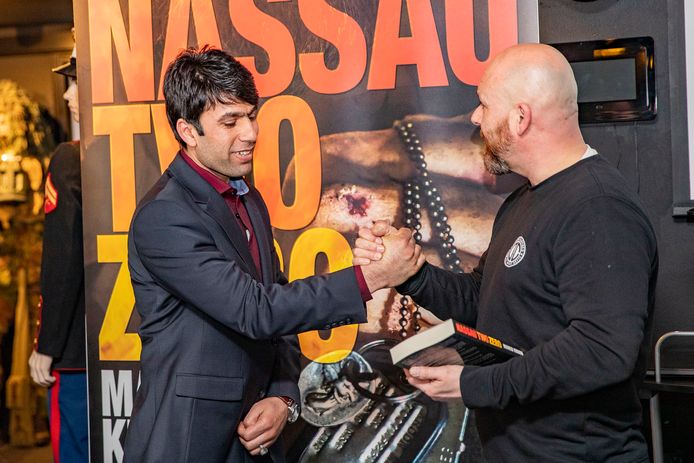 Marco Kroon (rechts) reikt het eerste exemplaar van zijn nieuwe boek uit aan de Afghaanse tolk Wahid.