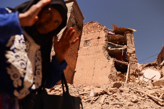 A woman from Al-Adsil stands in front of the partially destroyed mosque.