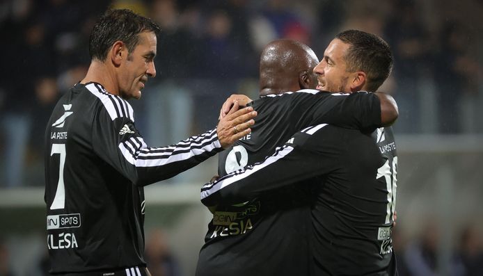 Vader Mbappé knuffelt Hazard na de goal, ook Pirès geeft een schouderklopje.