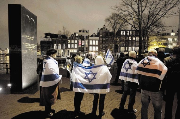 Bij de herdenking van de Kristallnacht, vorige maand in Amsterdam, droegen tientallen mensen een IsraÃ«lische vlag. (FOTO MARCEL ANTONISSE, ANP) Beeld ANP