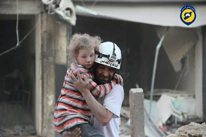 Archiefbeeld van een lid van de Syrische burgerbeschermingsbeweging Witte Helmen in actie in Aleppo. Het gaat om hulpverleners die gespecialiseerd zijn in de evacuatie van mensen vanonder het puin van gebouwen vernietigd door het Syrische leger of de Russische luchtmacht. Ze worden bedreigd met opsluiting of executie.