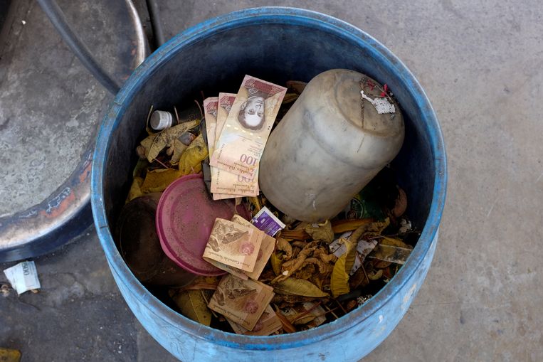 De bolívar is zodanig waardeloos geworden dat mensen zelfs bankbiljetten in de vuilnisbak kieperen. 
 Beeld REUTERS
