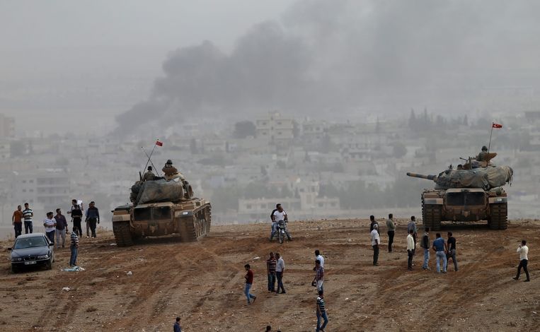 Turkse tanks en Turks-Koerdische inwoners nemen de gevechten in Kobani, aan de andere kant van de grens, waar. Beeld epa