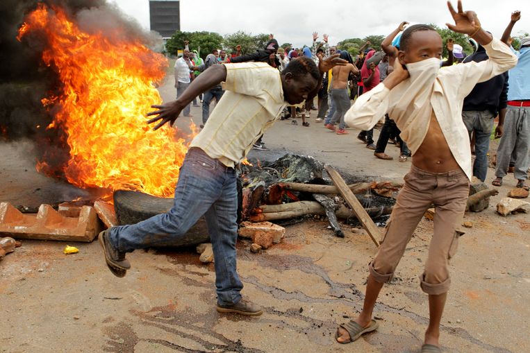 Brandende autobanden tijdens de rellen van vorige week in Harare. Beeld AP