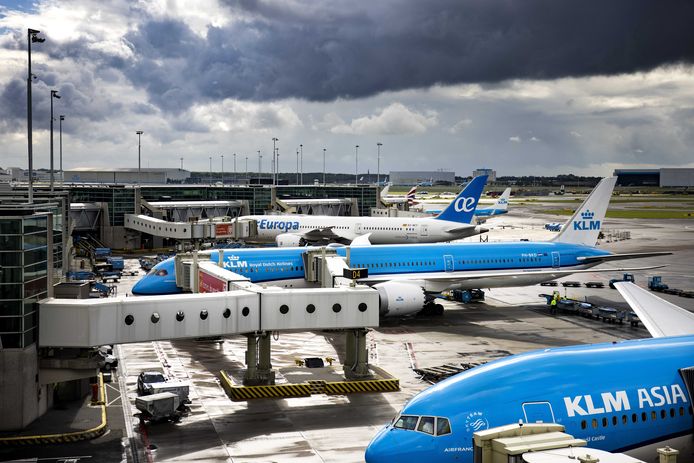 Verschillende KLM vliegtuigen wachten bij hun gate op Schiphol.