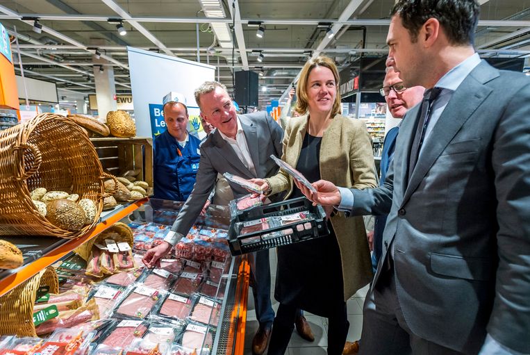 Staatssecretaris Martijn van Dam van Economische Zaken vult samen met Frank Dales van de Dierenbescherming en Marit van Egmond van de Albert Heijn de schappen van de Albert Heijn XL met diervriendelijker geproduceerde varkensvleeswaren.  Beeld 
