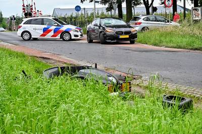 Scooterrijder botst hard tegen auto en moet gewond naar het ziekenhuis: flinke ravage op de weg