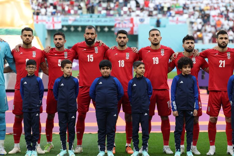 Iraanse voetballers houden de lippen stijf op elkaar tijdens het volkslied.  Beeld AFP