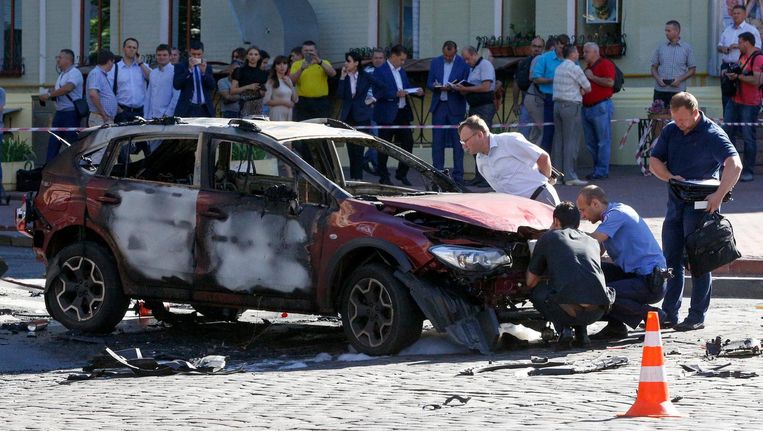 Forensische onderzoekers bij de geëxplodeerde auto. Beeld ap
