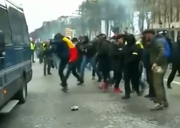 Op beelden is te zien hoe een relschopper getooid in Belgische vlag tekeer gaat tegen een politievoertuig.
