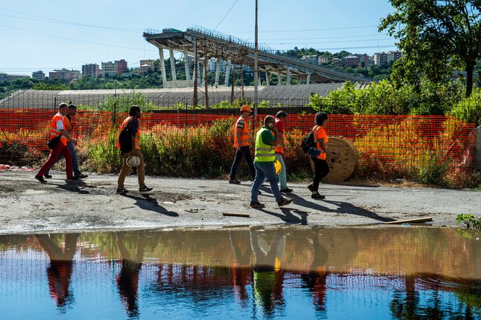 Ingenieurs en arbeiders inspecteren de omgeving van de ingestorte brug in Genua.