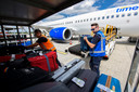 Medewerkers van het bedrijf Viggo doen op Eindhoven Airport de bagage-handelingen.