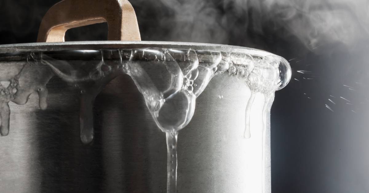 femme verser l'eau de robinet dans électrique bouilloire à le