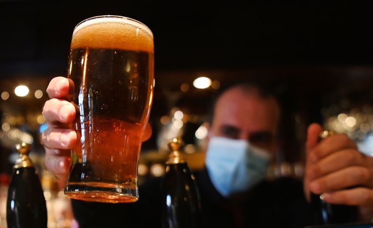 Een barman serveert een pint bier in een Londense pub. Beeld EPA