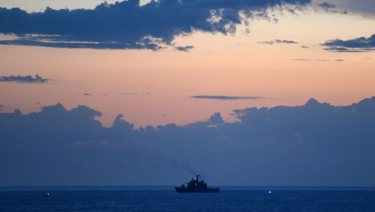 Een millitair schip voor de kust van Lampedusa waar ook gisteren nog tientallen lichamen werden geborgen. Beeld afp