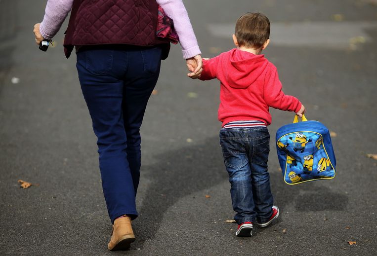 Een moeder loopt met haar zoontje naar school. Beeld BELGAIMAGE