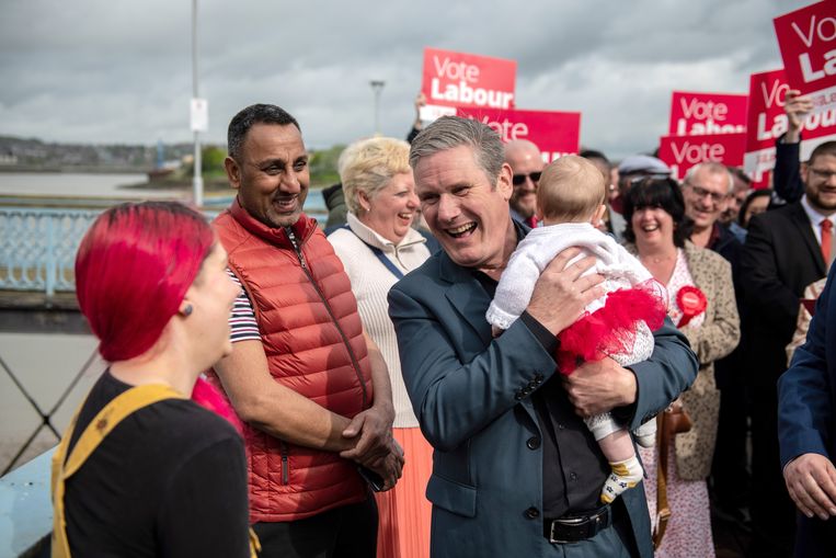 Labor leader Keir Starmer, with a five-month-old baby from one of the passers-by in his arms, among his supporters on Election Day in Chatham, just south-east London.  ImageGetty Images