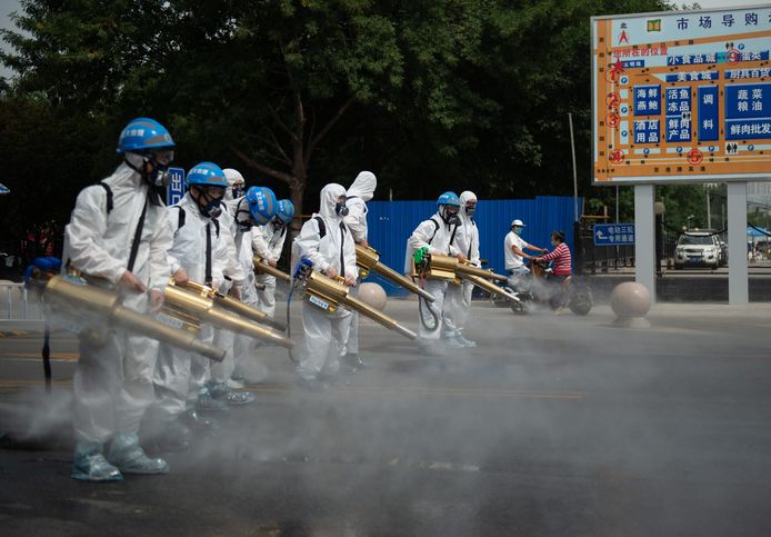 De 'ghostbusters' ontsmetten dinsdag met dampkanonnen de omgeving van de voedselmarkt Yuegezhuang in Peking. (1/2)