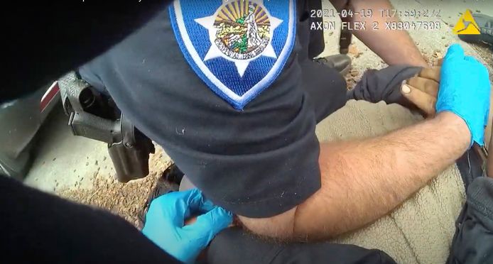 Mario Gonzalez wordt met zijn armen op zijn rug tegen de grond gewerkt door de politie.