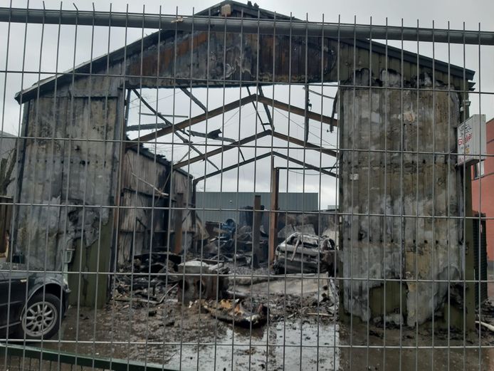 De loods van het autobedrijf in Helmond bij daglicht na de brand.