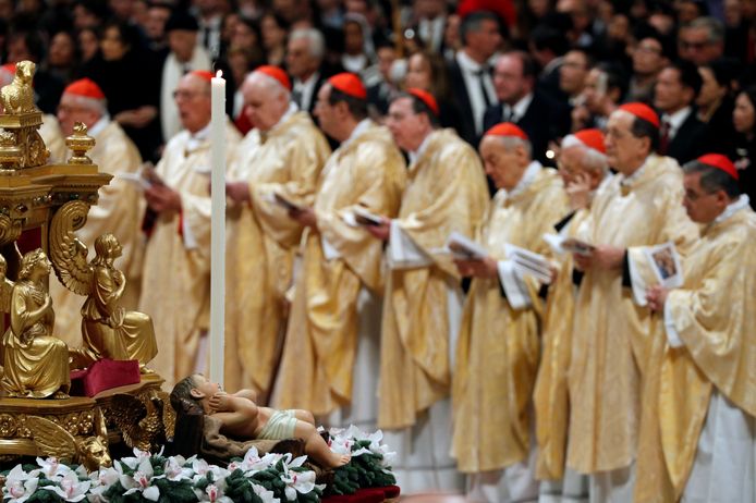 Kardinalen in gouden gewaden wonen de kerstnachtmis van de Paus bij in Rome.