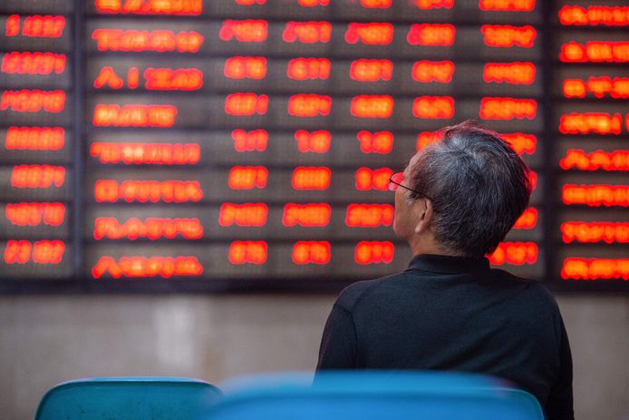 Een investeerder bekijkt de bewegingen op de beurs in Nanjing, China. Groen staat in China voor koersdalingen, rood voor winst.