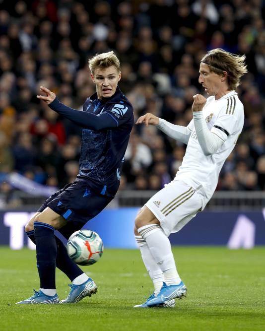 Martin Odegaard (links) in een gevecht om de bal met Luka Modric.