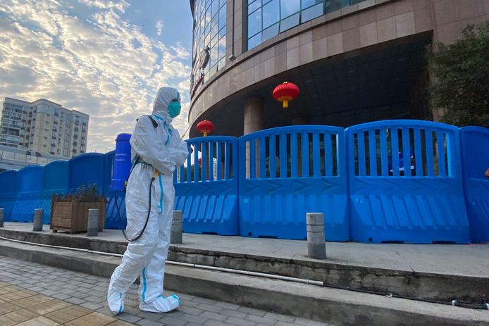 Een stadsarbeider met ontsmettingsmiddel aan het Centraal Ziekenhuis van Wuhan.