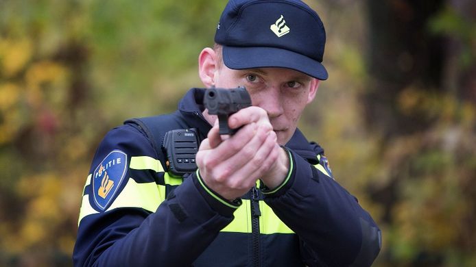 Foto ter illustratie: een agent richt zijn wapen bij een oefening van de politie.