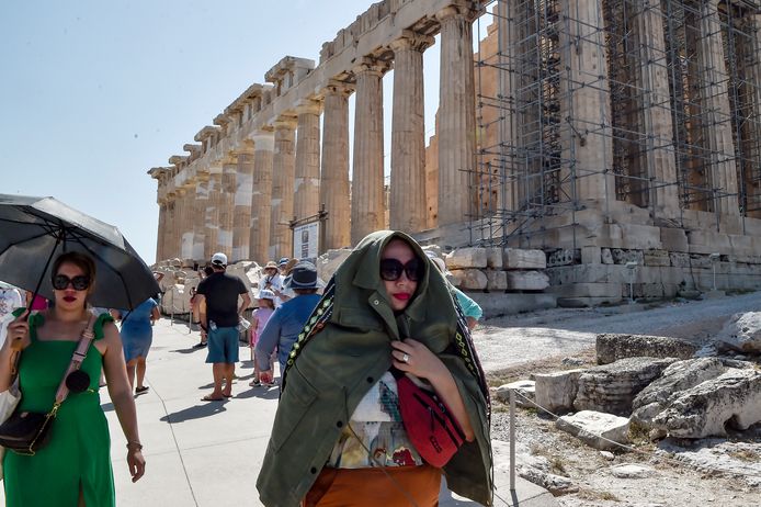 Bezoekers schuilen voor de zon in de Akropolis in Athen.