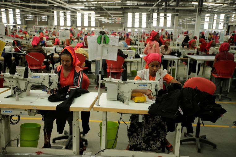 Werksters naaien kleren aan elkaar in de Indochine Apparel PLC textielfabriek in Ethiopië.  Beeld REUTERS