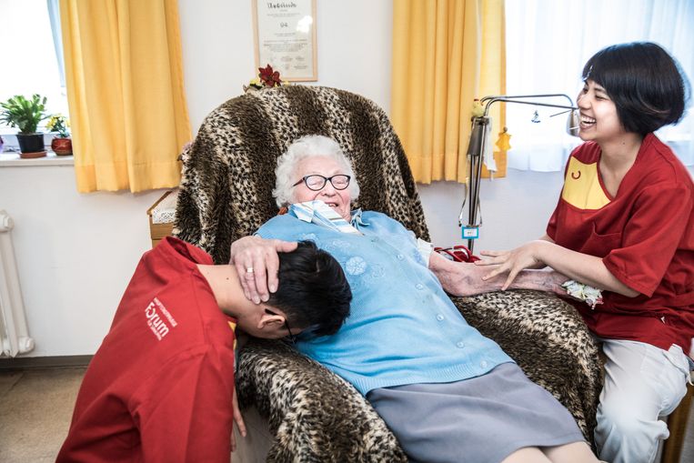 Een oudere vrouw en twee verplegers in verpleeghuis Louise Schroeder in Berlijn.  Beeld Waldthausen Marlena