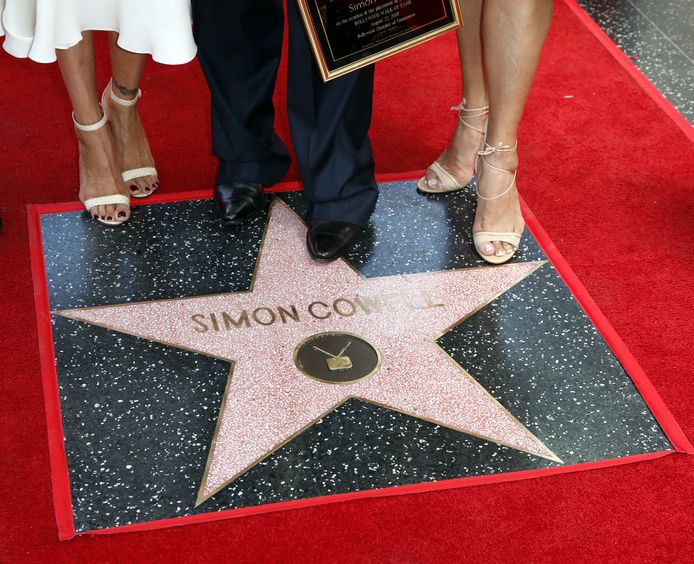 epa06965256 UK producer and television host Simon Cowell (C) stands on his star with two guests during a ceremony  honoring him with a star on the  Hollywood Walk of Fame in Hollywood, California, USA, 22 August 2018. Cowell received the 2,642nd star in the Television category.  EPA/MIKE NELSON