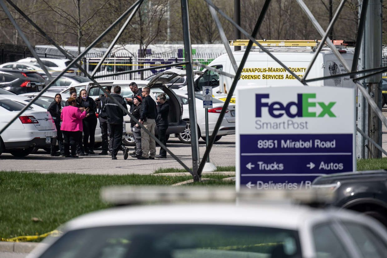Politieagenten verzamelen na de schietpartij op het parkeerterrein van het FedEx-filiaal. Beeld Getty Images