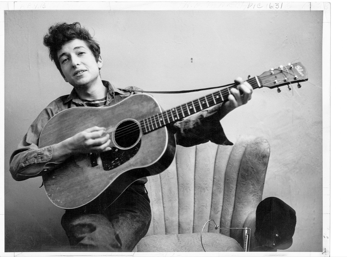 Bob Dylan poseert met zijn Gibson gitaar.