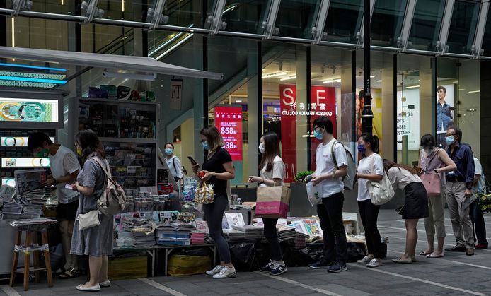 Mensen staan in de rij voor een krantenkiosk in Hongkong om een exemplaar van de Apple Daily te kopen.