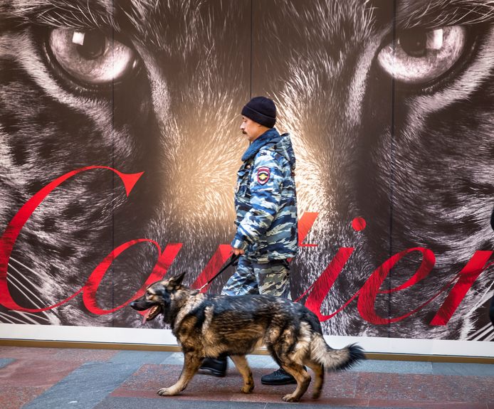 Een agent houdt met zijn hond een oogje in het zeil op het Rode Plein in Moskou.