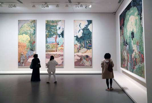 Een vrouw bekijkt schilderijen van de Morozov-collectie in de Fondation Louis Vuitton in Parijs.