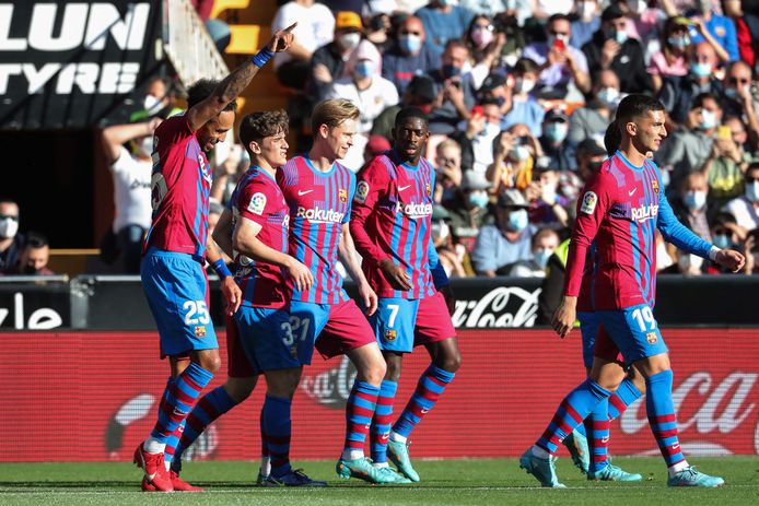 Spelers van FC Barcelona vieren een goal tegen Valencia.