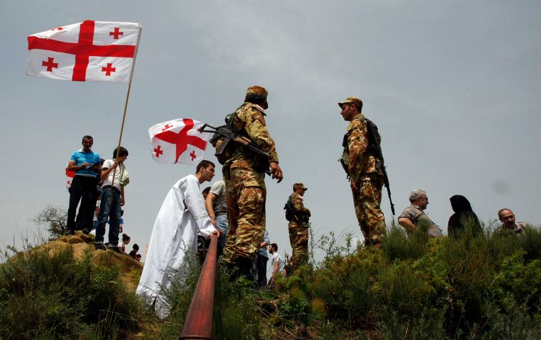 Georgische grenspolitie controleert pelgrims.  Beeld AP