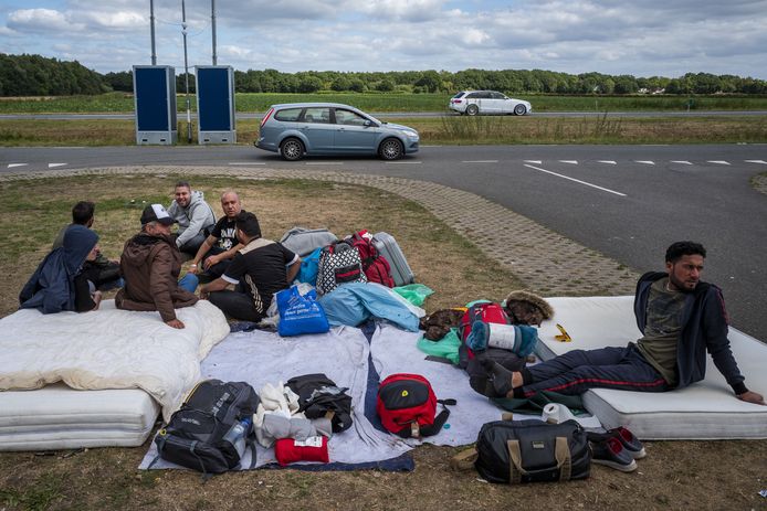 Asielzoekers buiten de poort bij het aanmeldcentrum in Ter Apel. Nacht na nacht slapen honderden mensen buiten het aanmeldcentrum.