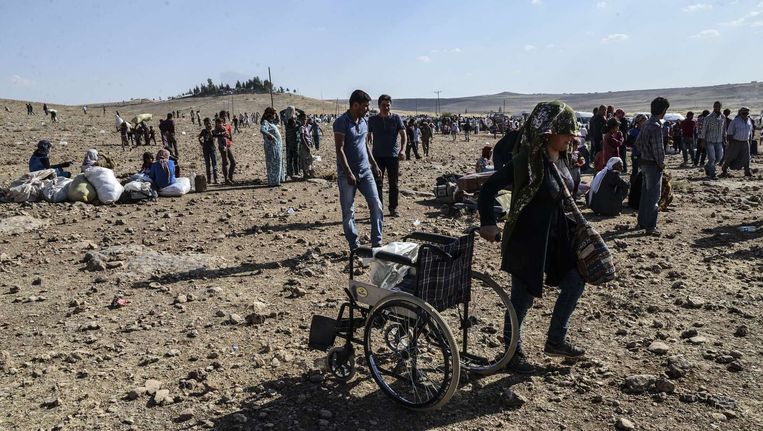 Syrische Koerden dragen hun bezittingen over de grens naar Turkije nadat ze gevlucht zijn voor IS-geweld. Beeld afp