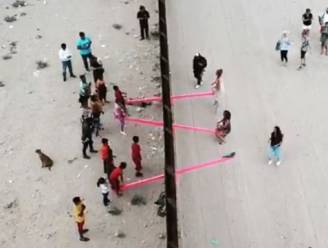 Amerikanen en Mexicanen genieten samen van roze wipplanken dwars door grenshek