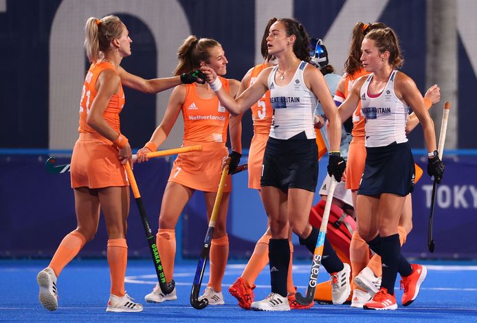De speelsters van Oranje en Groot-Brittannië begroeten elkaar voor de wedstrijd.