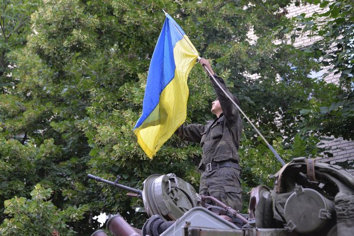 Een soldaat in de weer met de Oekraïense vlag in Donetsk. Archiefbeeld ter illustratie.
