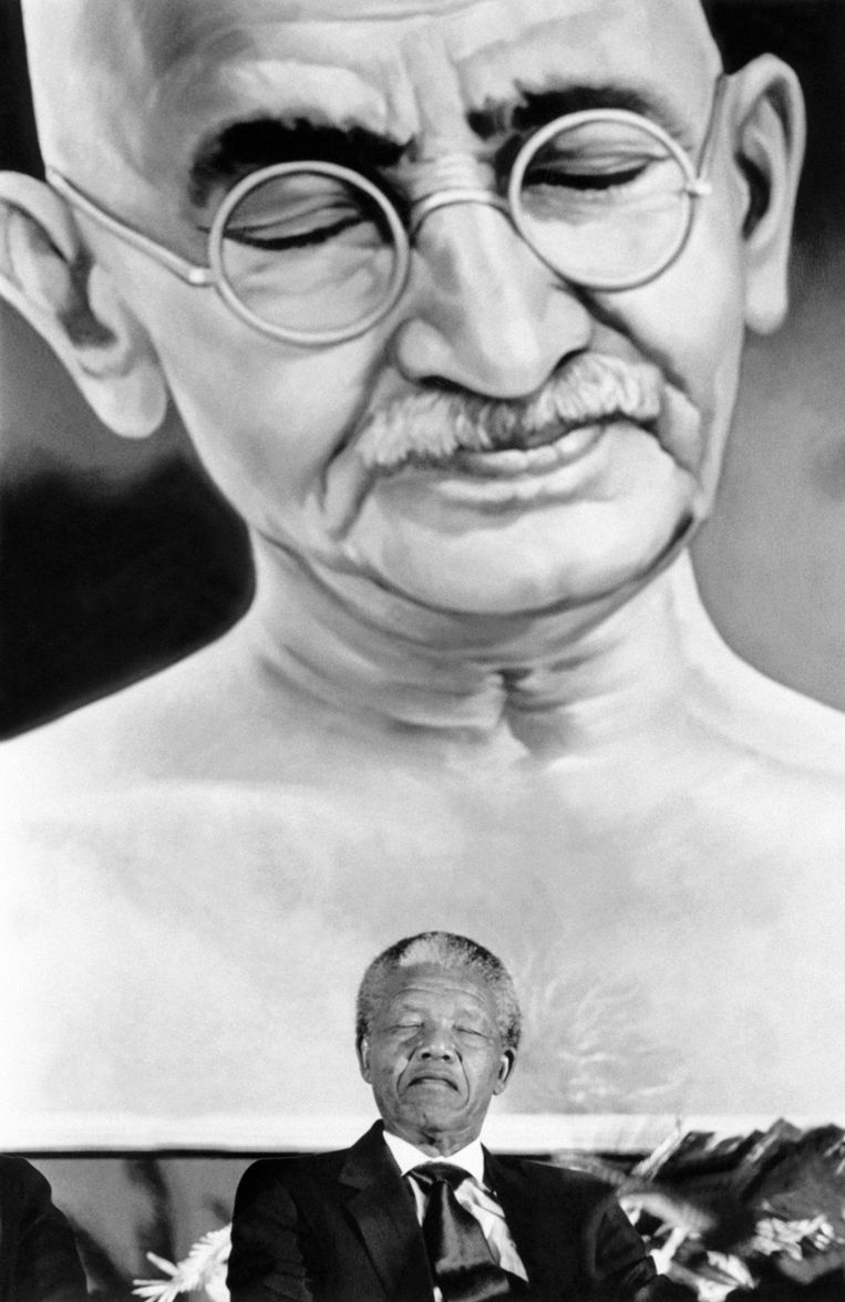 1990: Mandela voor een portret van Mahatma Gandhi, bekend om zijn principe van geweldloos verzet, in New Dehli. Beeld AFP/EPA/ANP