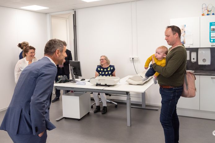 Staatssecretaris Paul Blokhuis begroet baby Job en zijn vader bij het bezoek aan het consultatiebureau van de jeugdgezondheidszorg van de GGD.