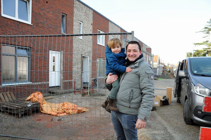 Rik van Klinken en zoontje Collin (1)  bij woningen die gebouwd worden aan het einde van zijn straat. Hijzelf is net een paar dagen geleden verhuisd naar een nieuw huis in de Schoolstraat in Bruinisse.