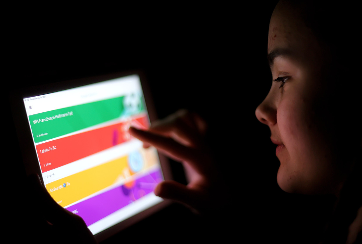 Een meisje gebruikt de app Google Classroom. Beeld EPA